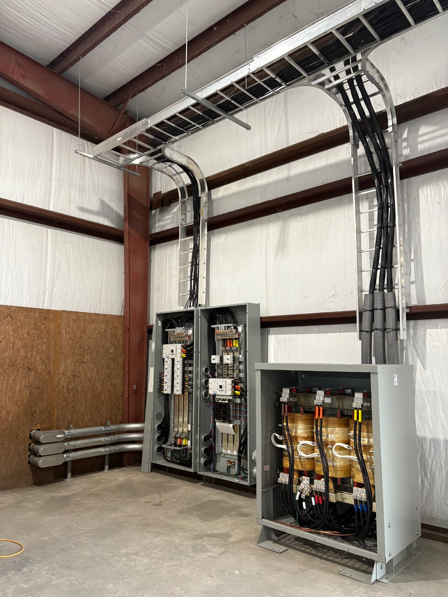 Two electrical boxes are sitting next to each other in a building.