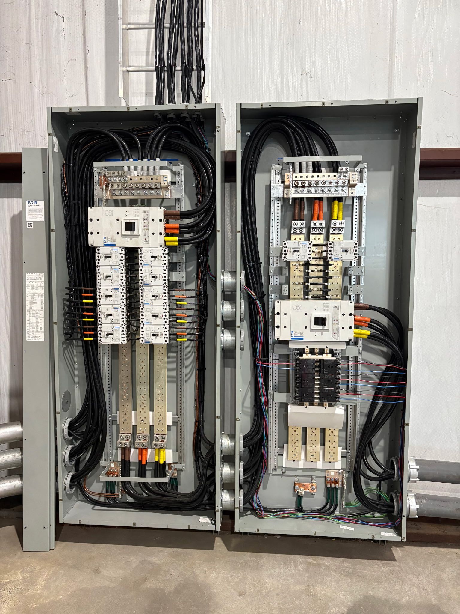 Two electrical panels are sitting next to each other on the ground.