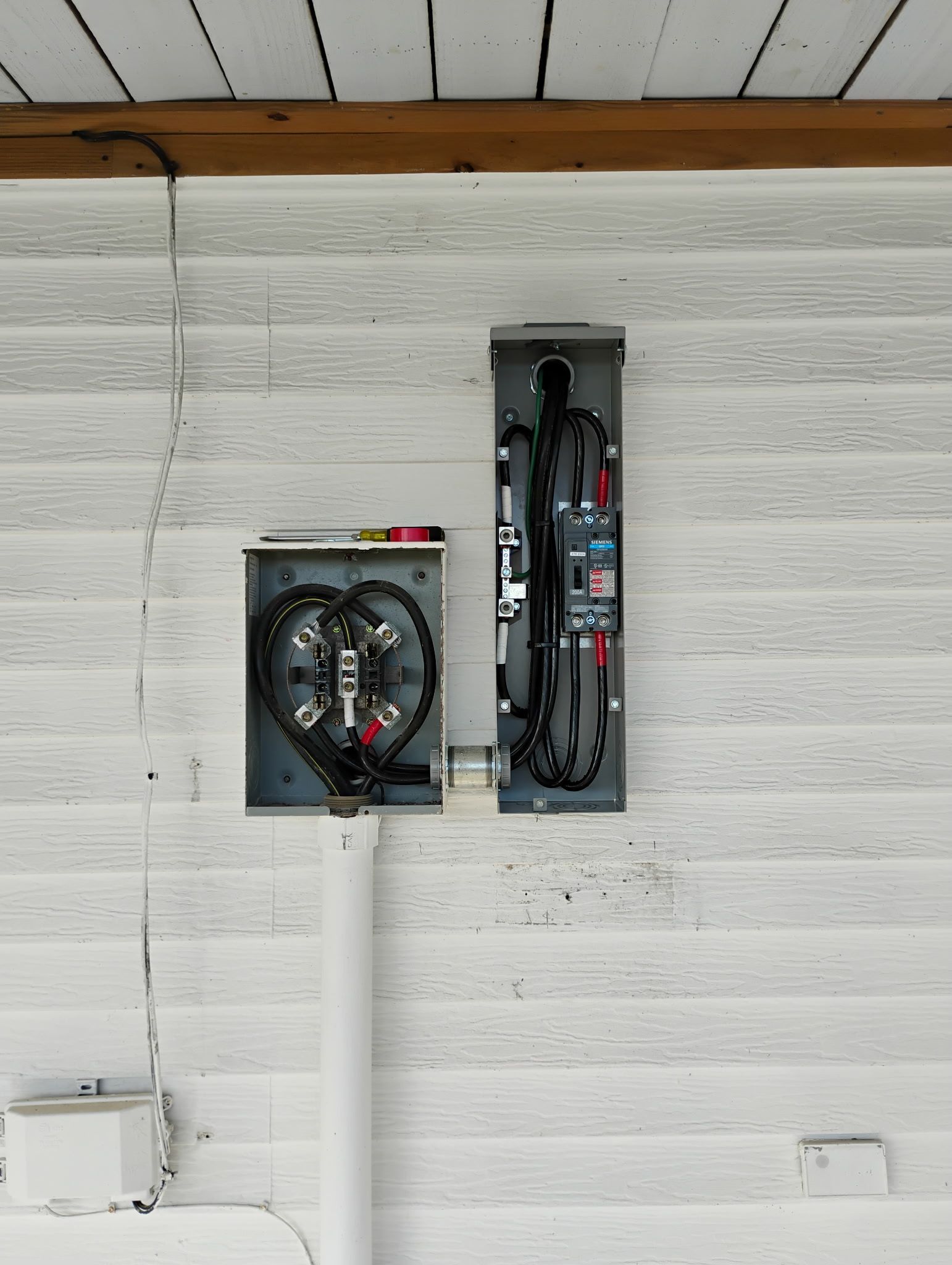 A white wall with two electrical boxes on it