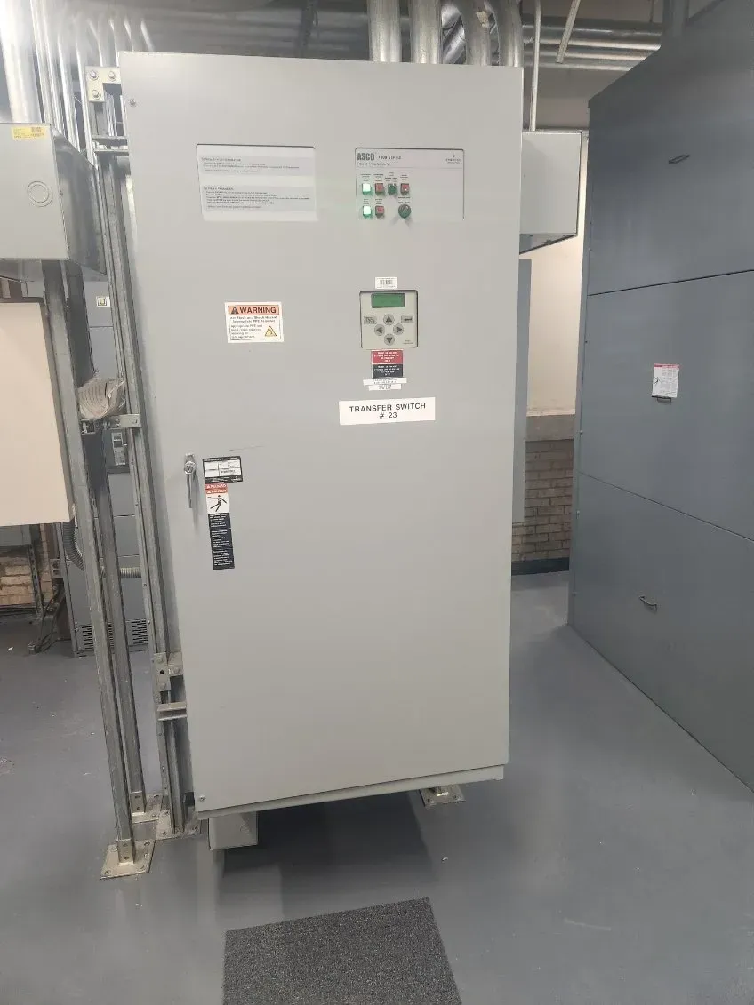 A large electrical box is sitting on the floor in a room.