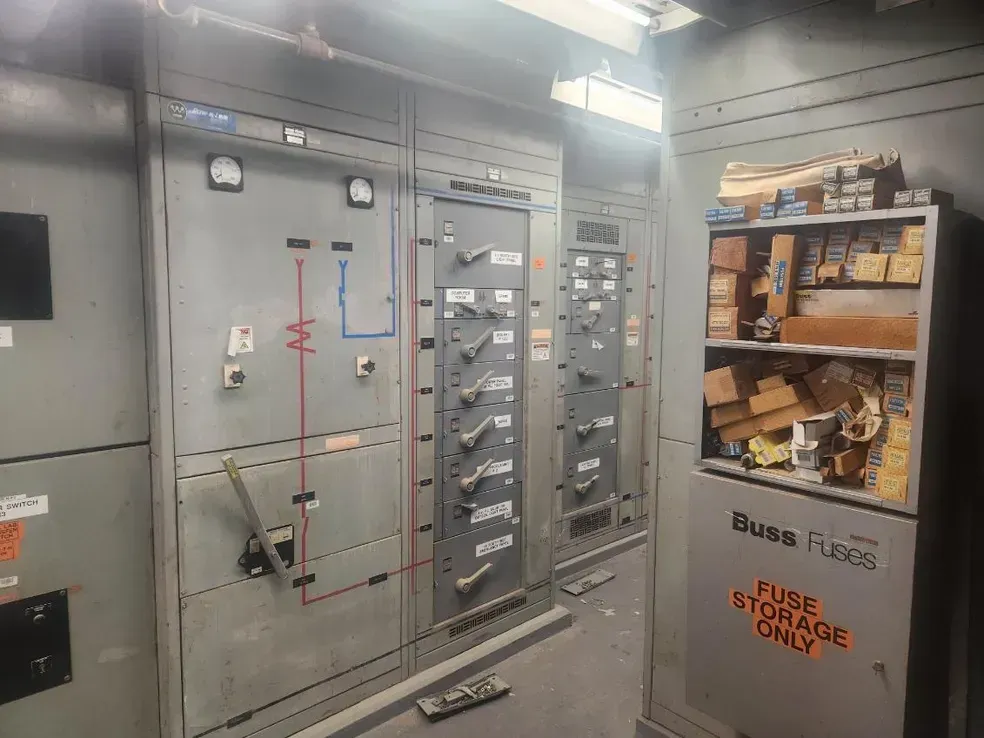A room with a lot of electrical panels and shelves.