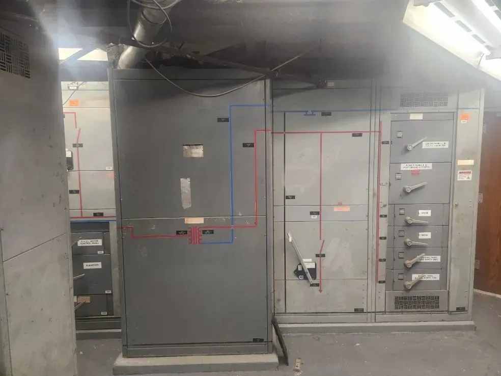 A room with a lot of electrical boxes and a smoke coming out of the ceiling.