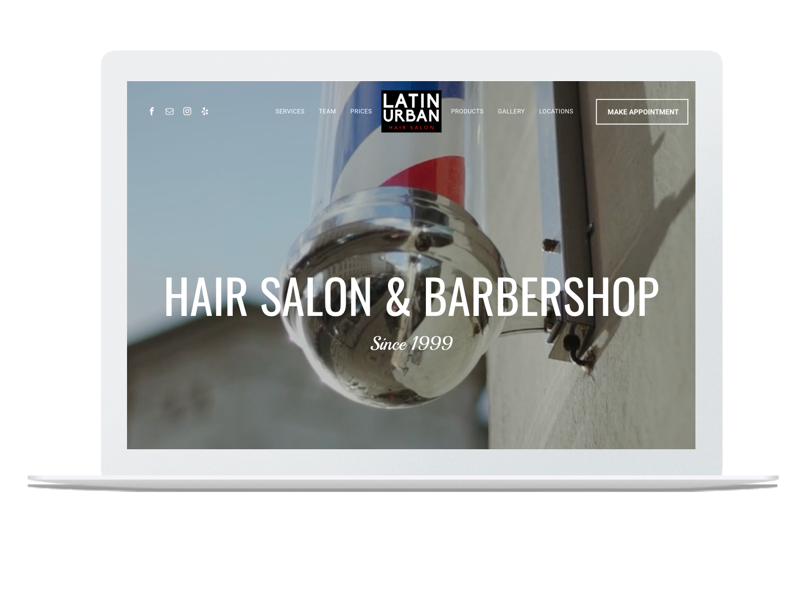 A laptop is open to a website for a hair salon and barbershop.