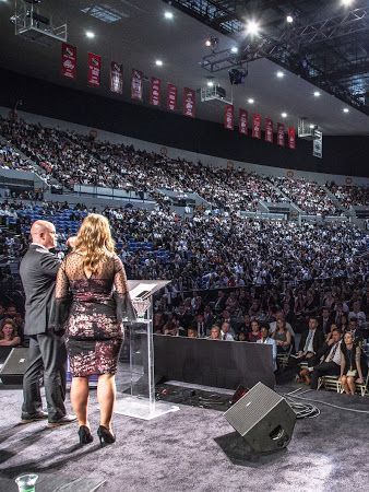 Speaking on stage is Tye and Ann Rustrum