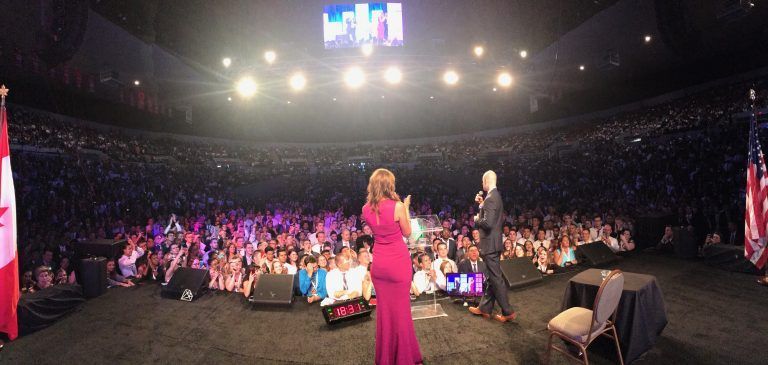 Tye speaking on stage with Ann