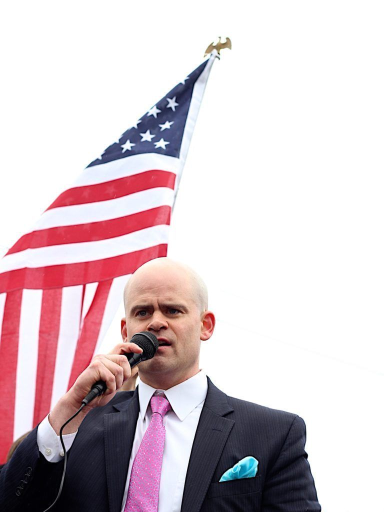 Tye speaking with the american flag