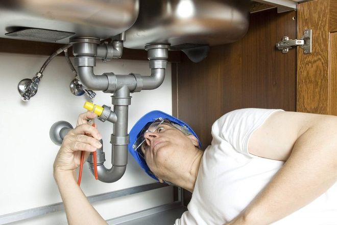 a man is fixing a sink with a screwdriver