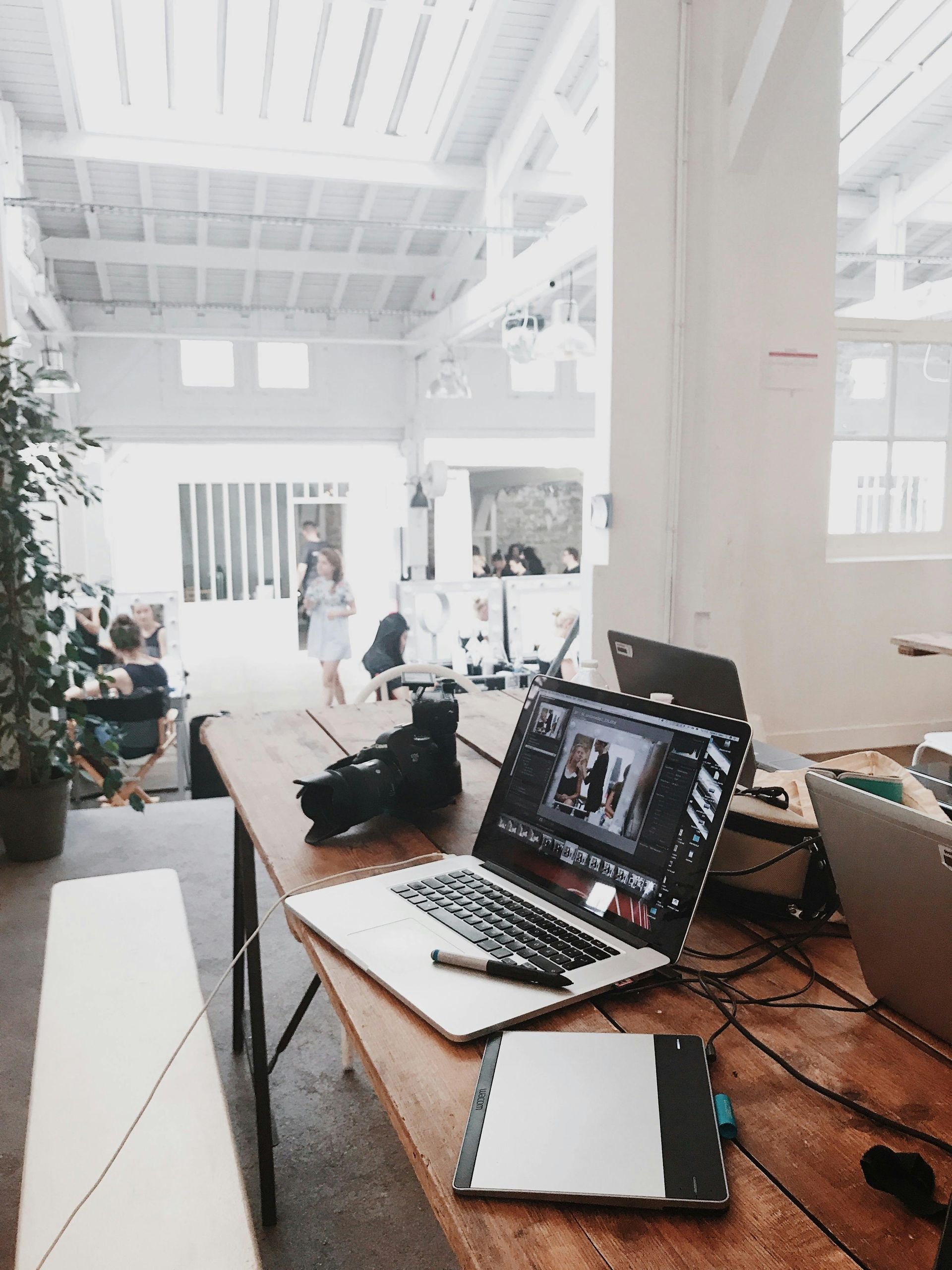 A laptop is sitting on a wooden table in a room.