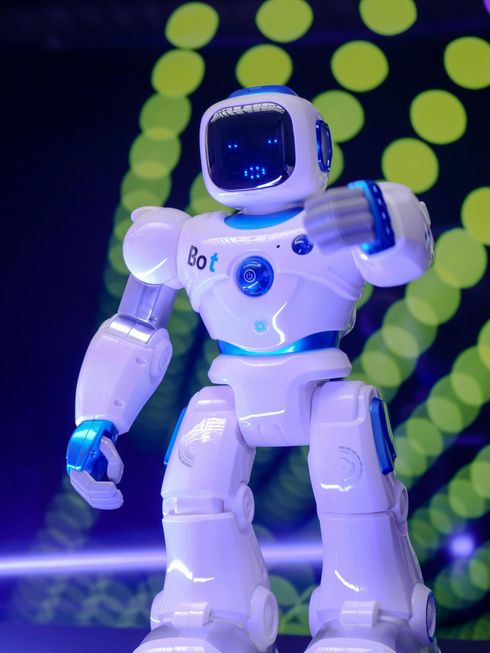 A white and blue robot with the word bot on it