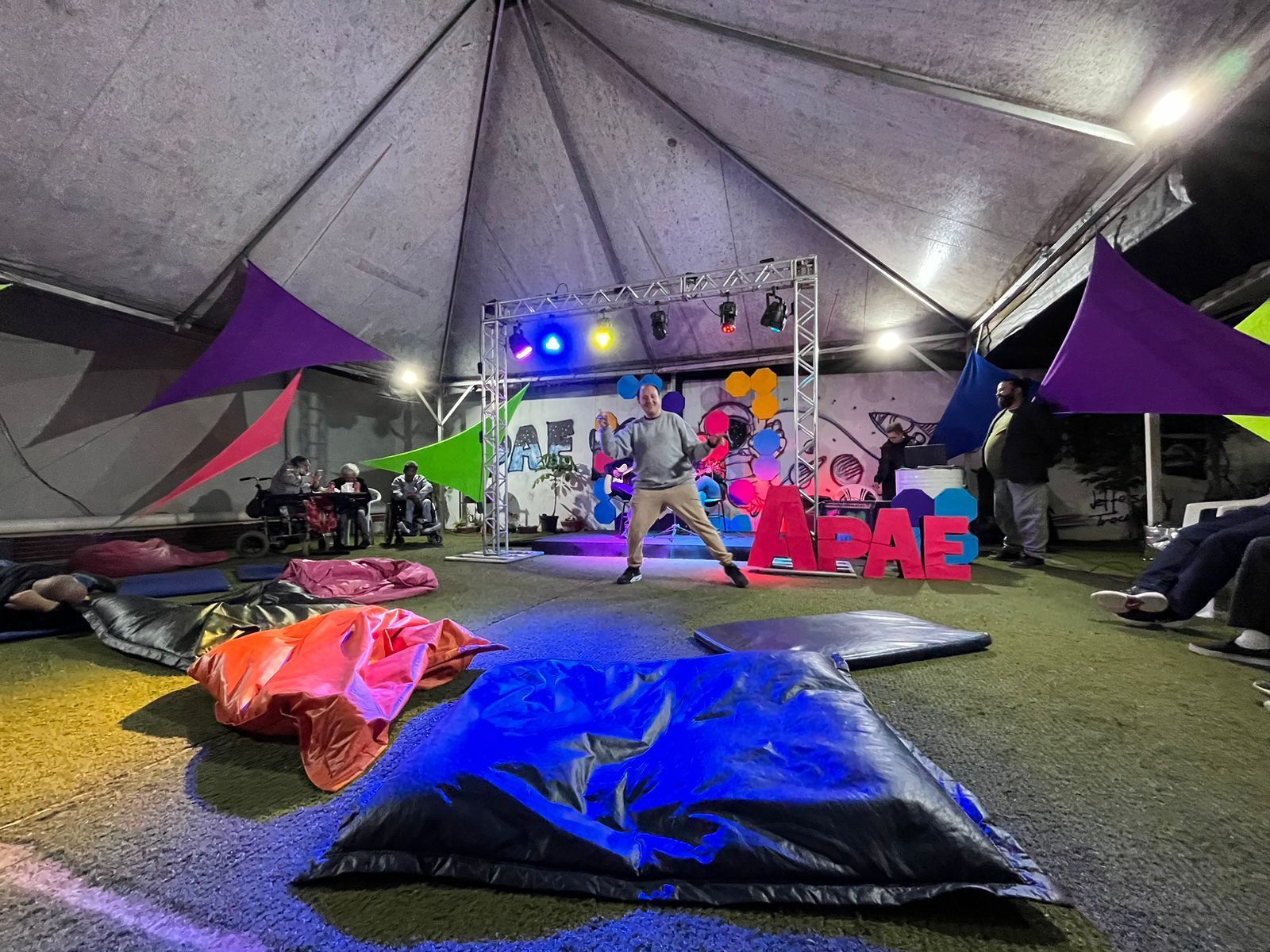 O mês de maio é marcado por importantes lutas sociais no Brasil, que visam a construção de uma sociedade mais justa, inclusiva e livre de opressões. É um período de conscientização, resistência e mobilização em torno de pautas fundamentais como: Anticapacitismo, Anti Racismo, Luta Antimanicomial, Combate a LGBTfobia, e Combate ao Abuso e à Exploração Sexual de Crianças e Adolescentes.
É partindo dessas temáticas, de memorar esses processos históricos e essas lutas sociais que nasce o Sarau da APAE Sorocaba, buscando também entender os enfrentamentos sociais necessários para a construção de uma sociedade inclusiva e sem violências. Pensando nisso, foi elaborada e organizada a primeira edição do evento “Sarau Lutas de Maio” em 2019, no qual, por meio de apresentações artísticas criadas por usuários, palco aberto, exposição de artes e entre outras manifestações, tratamos das temáticas anteriormente citada,
Em maio de 2021 realizamos o evento com a proposta inicial de abrir as portas da instituição para a comunidade, criando um espaço de convivência, acolhimento, reflexão e fruição artística. Desde então, anualmente realizamos o evento “Sarau Lutas de Maio”, com a perspectiva de abrir para a comunidade temáticas que estão sendo trabalhadas dentro do Centro de Convivência e Fortalecimento de Vínculos da APAE Sorocaba, de apresentar e sensibilizar a comunidade sobre capacidades e potências das pessoas com deficiência, colocando em foco as lutas Anticapacitista, Anti racista, Anti LGBTfobia, Antimanicomial e Contra a exploração sexual de crianças e adolescentes, sendo as expressões artísticas que acontecem nesse evento, um meio e um fim no combate à exclusão social e segregacionismo. Todos os anos, temos momentos de palco aberto, no qual, todas as pessoas que se sentirem provocadas, podem participar da fruição deste momento e compor as apresentações.
Entendendo a importância e necessidade desse evento, convidamos a toda comunidade a participar da 6ª edição do “Sarau Lutas de Maio” que acontecerá no dia 23 de maio de 2025, das 18h às 22h, no espaço do Serviço de Convivência e Fortalecimento de Vínculos da APAE Sorocaba (local: Avenida Artur Bernardes, 655), será um momento de mobilização, resistência e muita celebração de temáticas tão importantes. Convidamos também as pessoas que queiram apresentar alguma manifestação artística, que se inscrevam por meio do link (https://bitly.cx/wf6ZD), e para aquelas que se sintam provocadas a compor o momento de apresentações, no momento do evento também teremos inscrições de palco aberto.
Esperamos vocês, até lá!