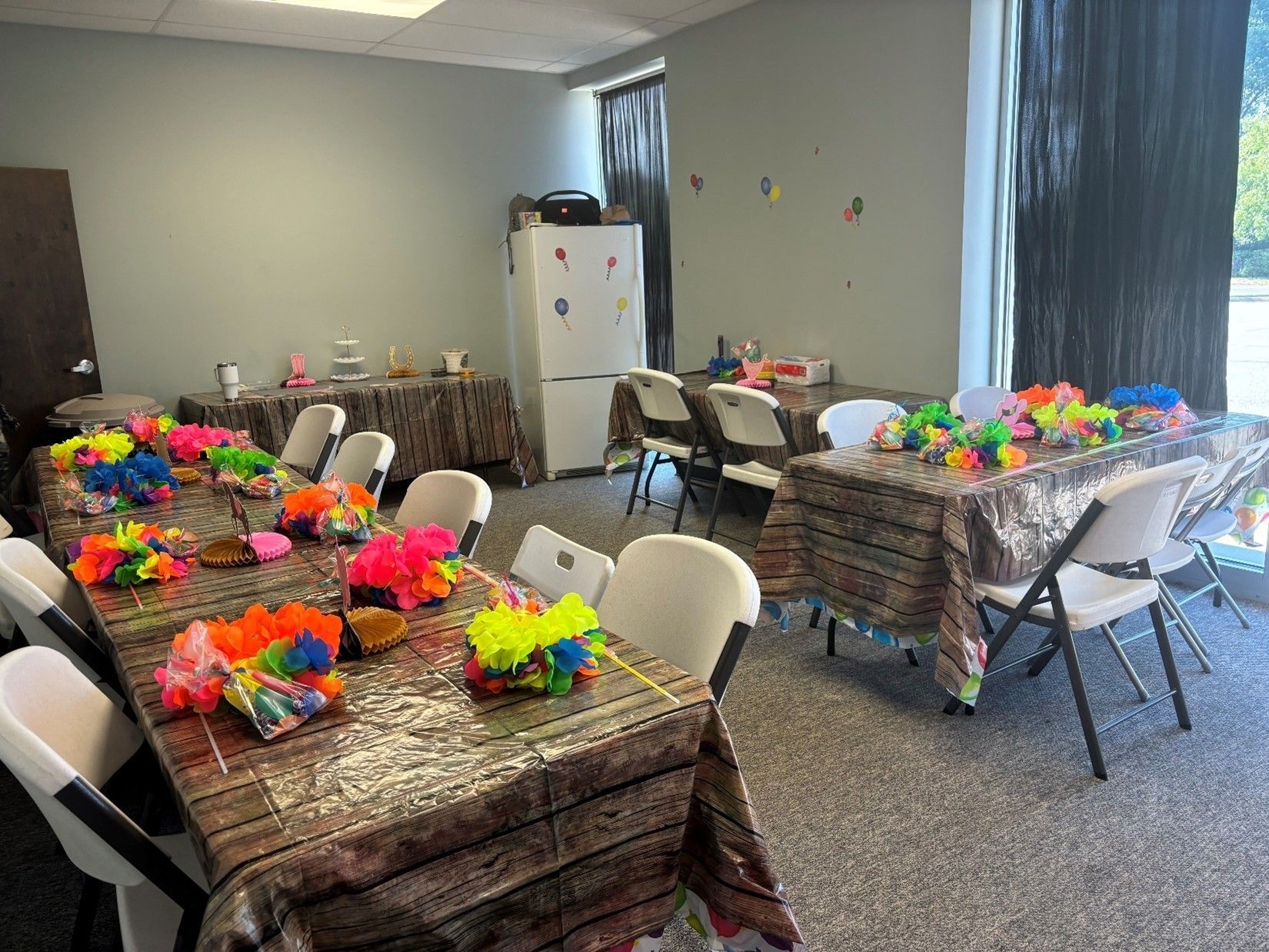 A room filled with tables and chairs decorated for a party.
