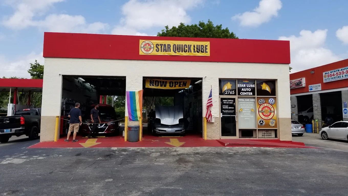 Star Quick Lube, red and beige building with two service bays. A car is in one. People wait outside | Star Quick Lube & Auto Care Center