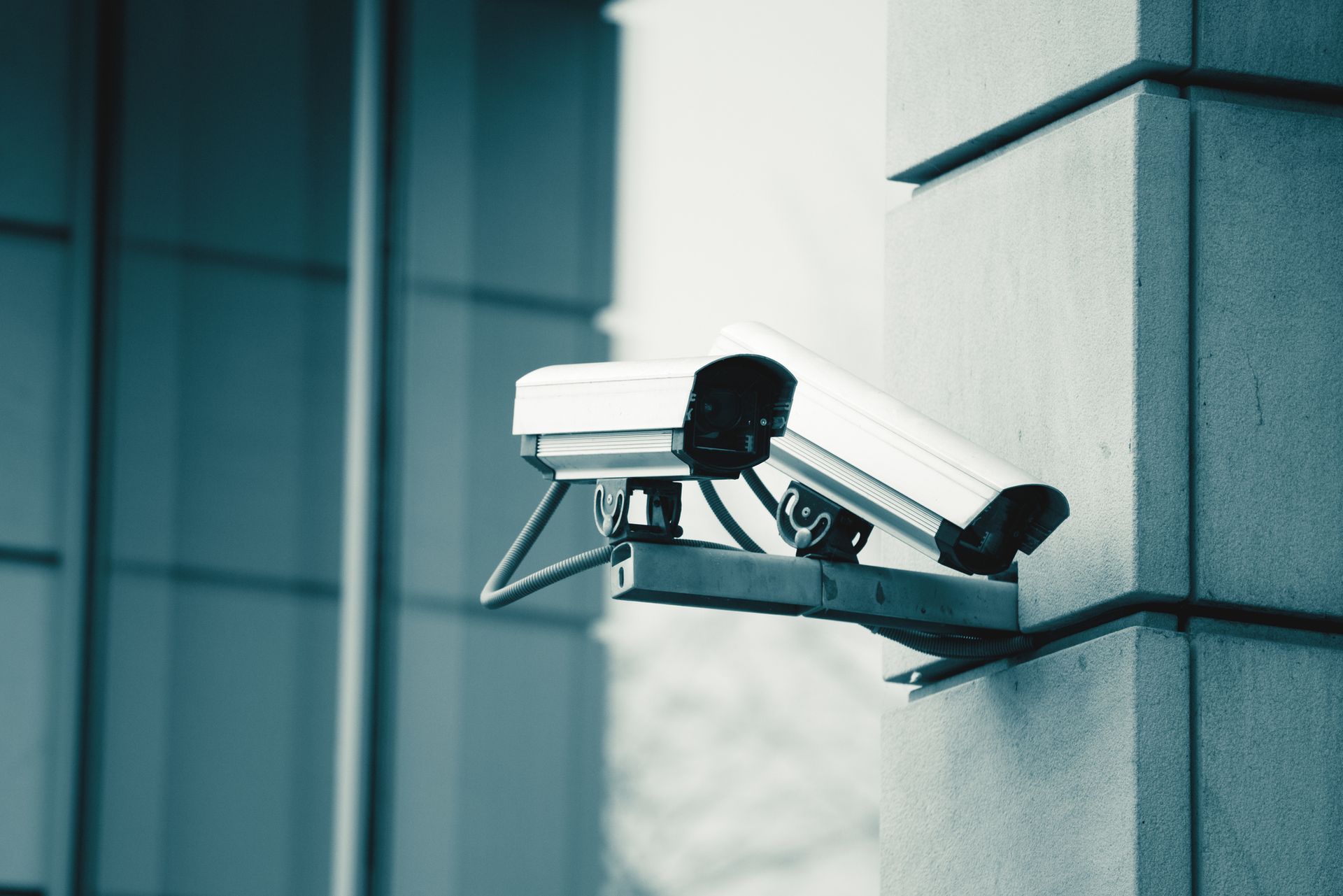 A surveillance camera on a pole under a bright blue sky, ensuring safety & security in the vicinity. 