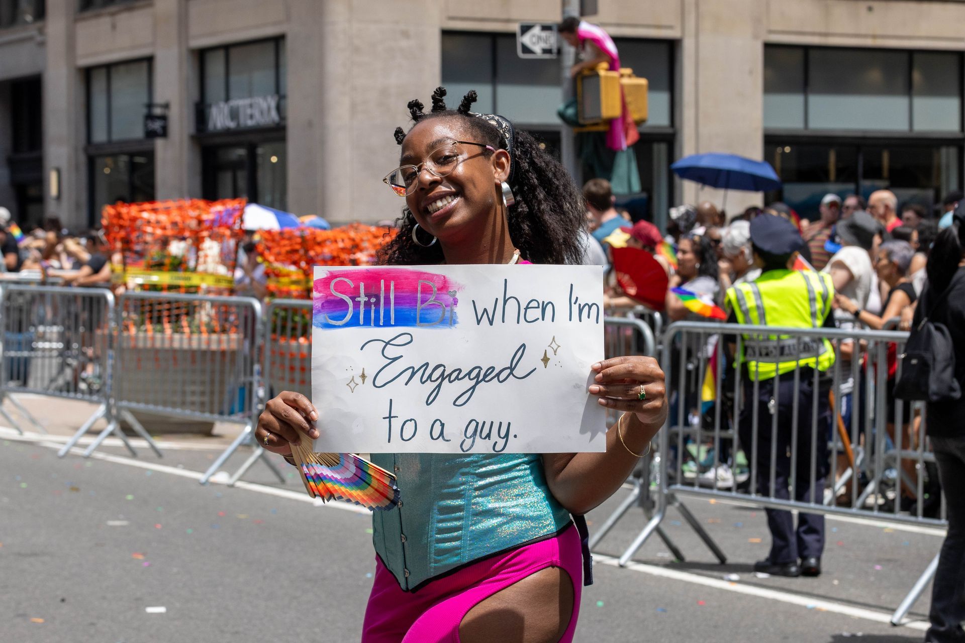 Woman at a pride parade holds a sign that reads 