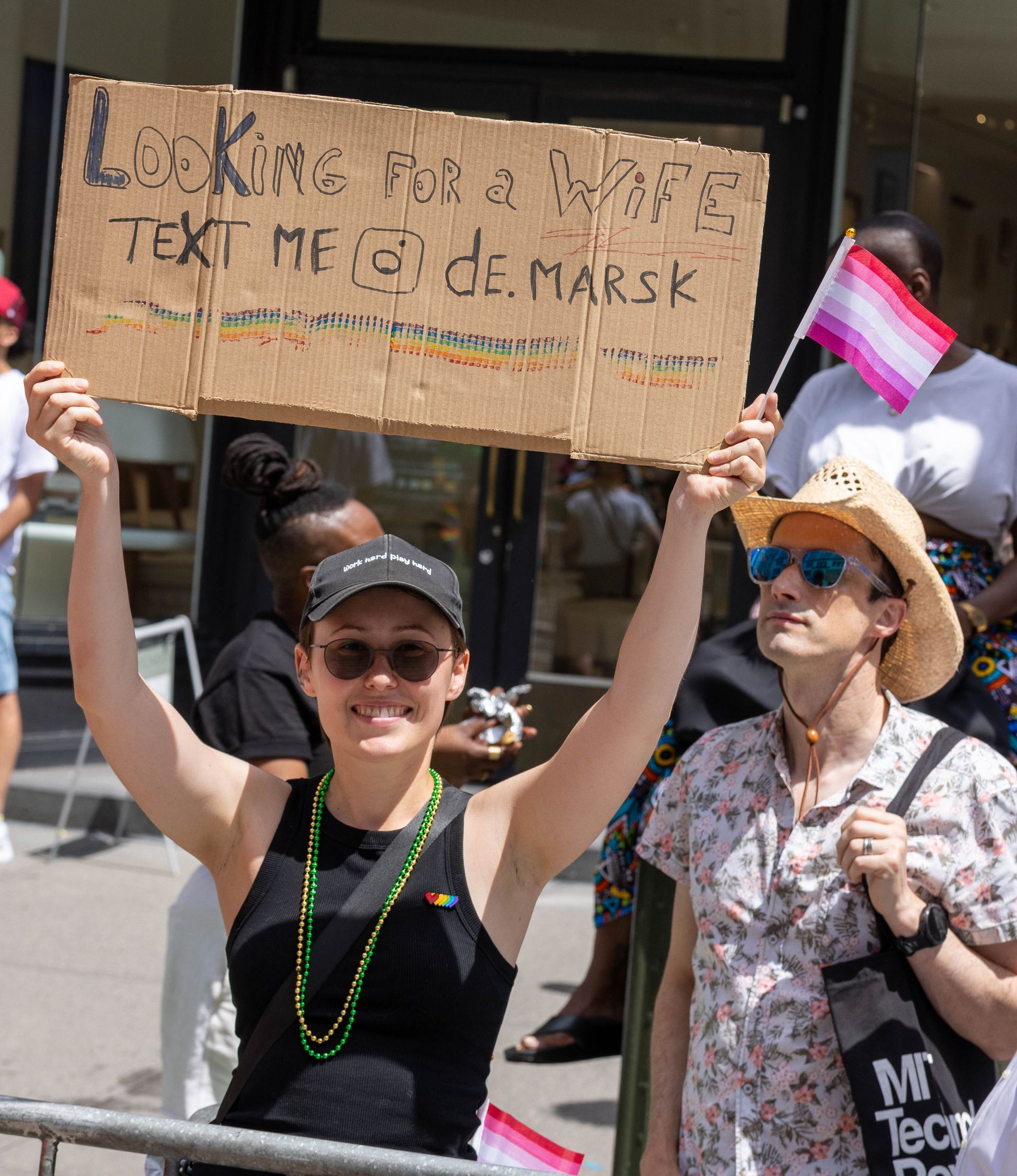 Person holding a sign at a Pride parade: 