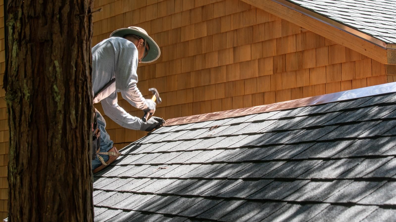 A man is working on the roof of a house.
