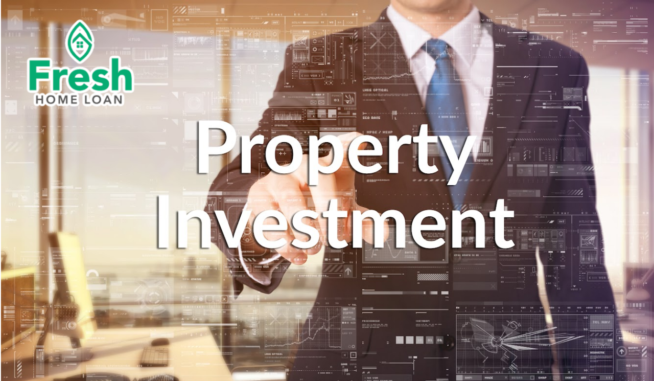 A man in a suit and tie is pointing at the word property investment.