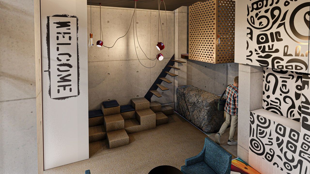 A room with a welcome sign on the wall and a staircase.