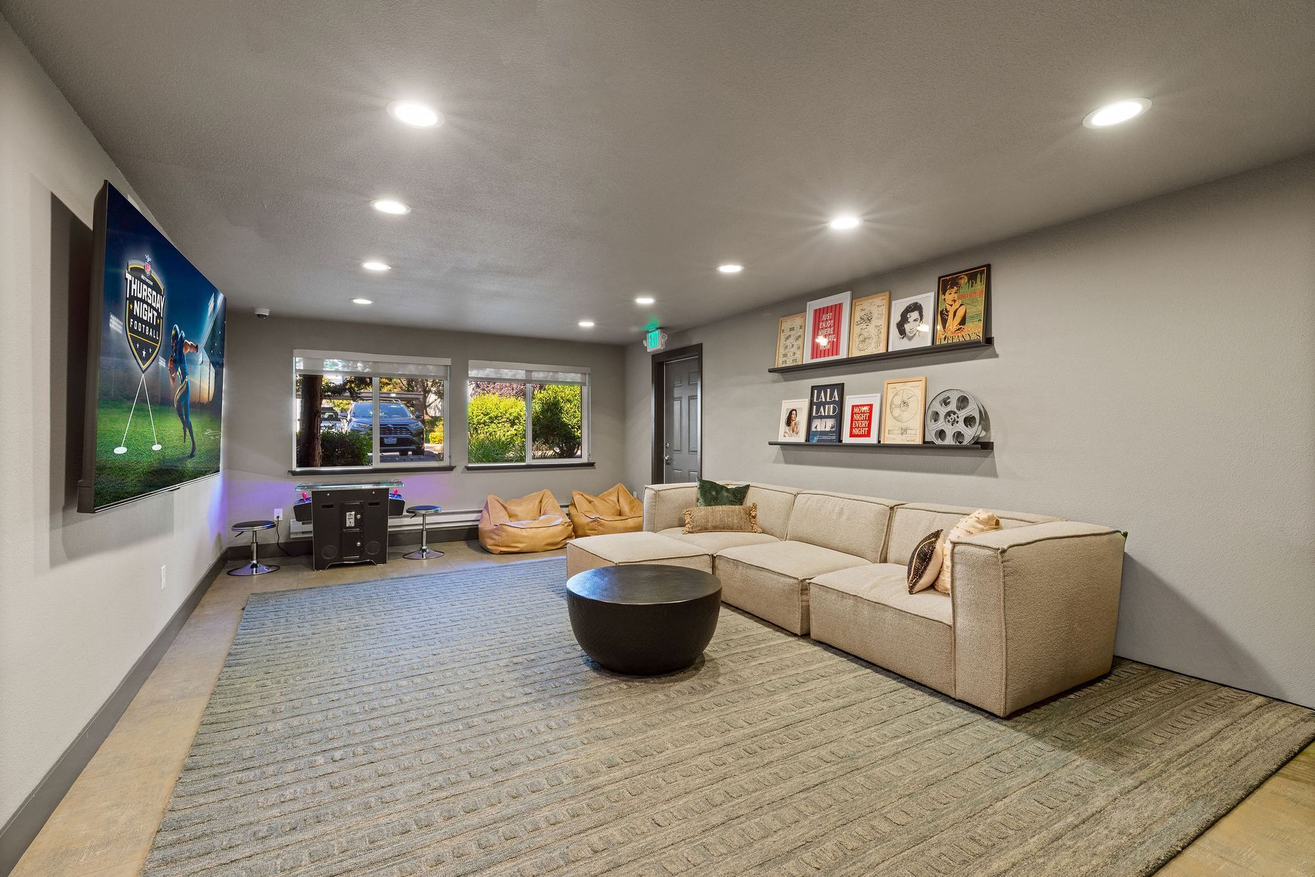 Modern living room with sectional sofa, large TV, and decor.