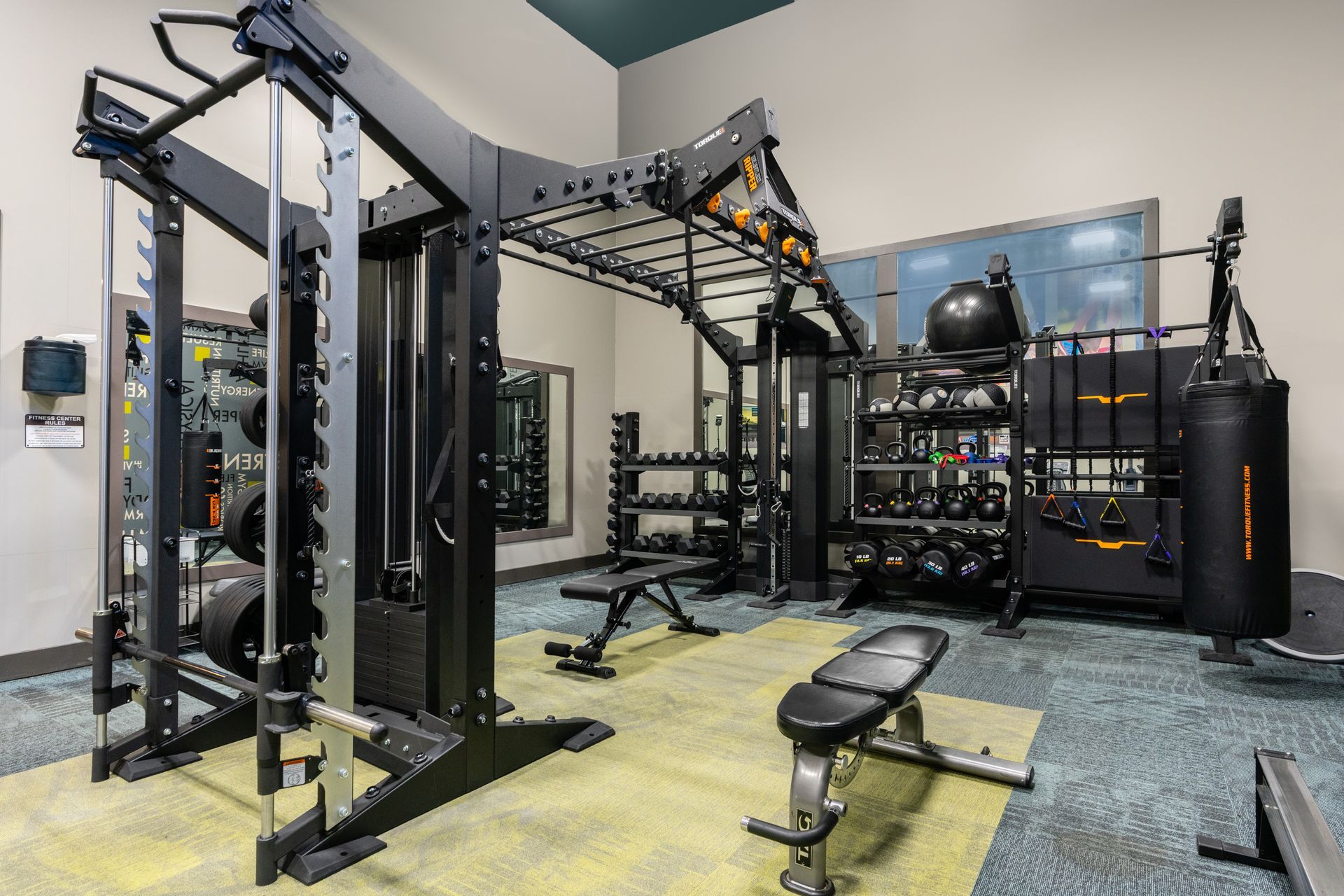 A gym filled with lots of exercise equipment and a large mirror.