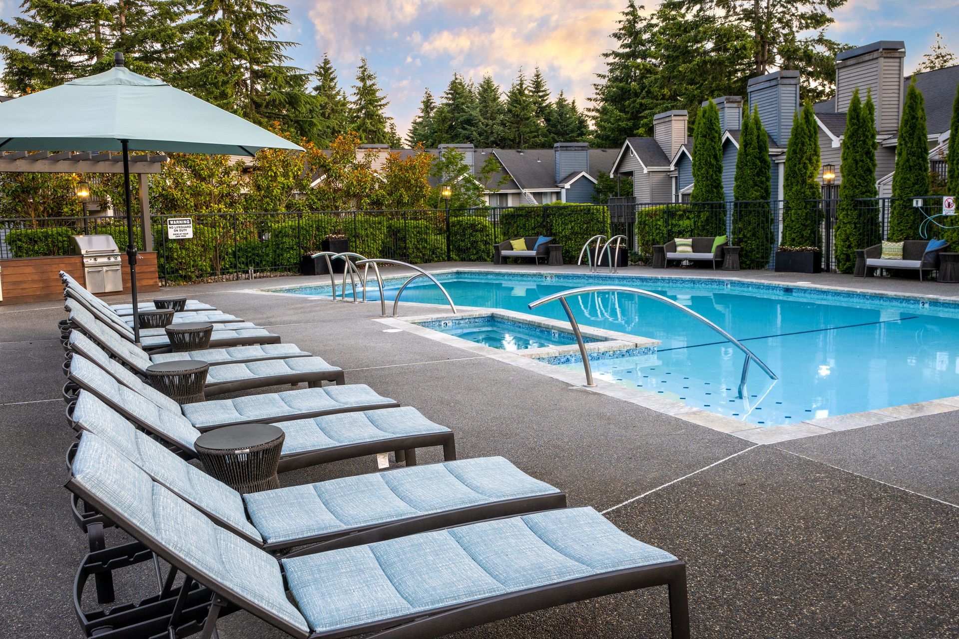 A large swimming pool surrounded by lounge chairs and umbrellas.