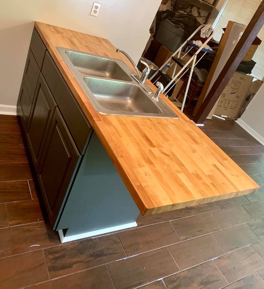 A kitchen with two sinks and a wooden counter top