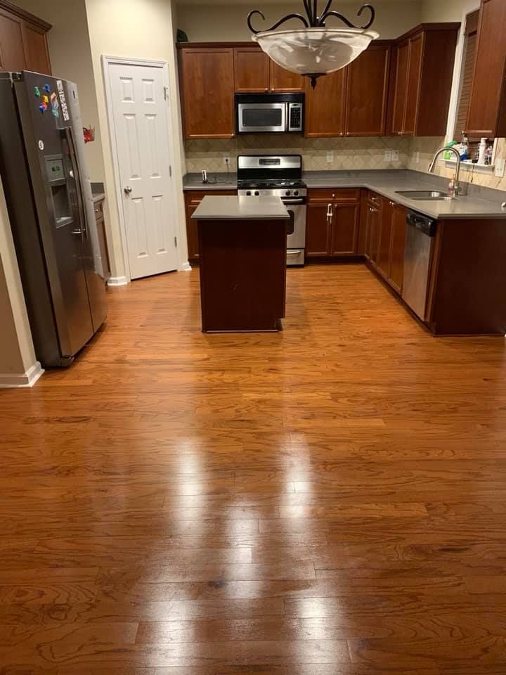 A kitchen with hardwood floors and stainless steel appliances.
