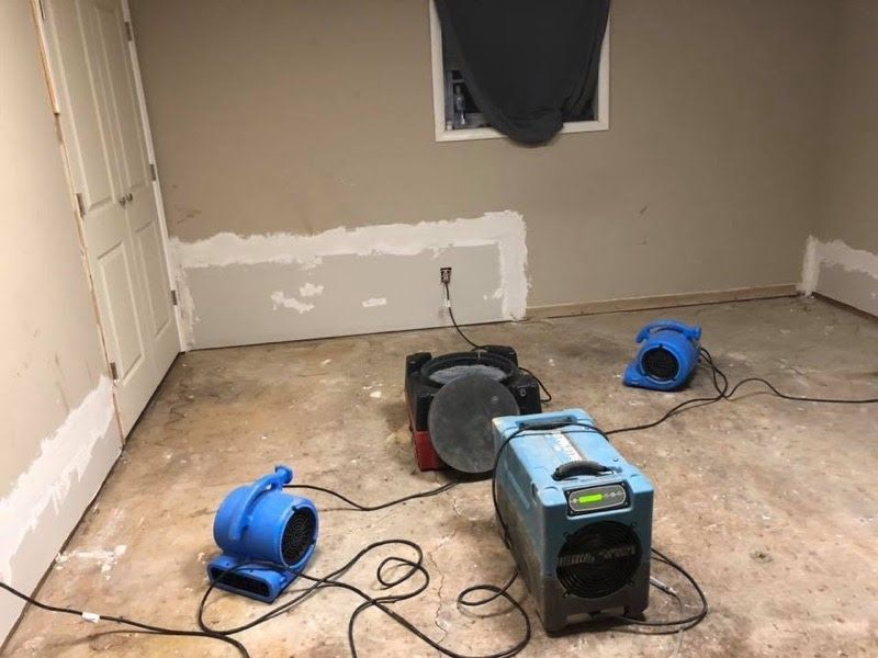 A room with three blue fans sitting on the floor.