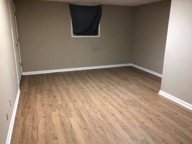 An empty room with hardwood floors and a window.
