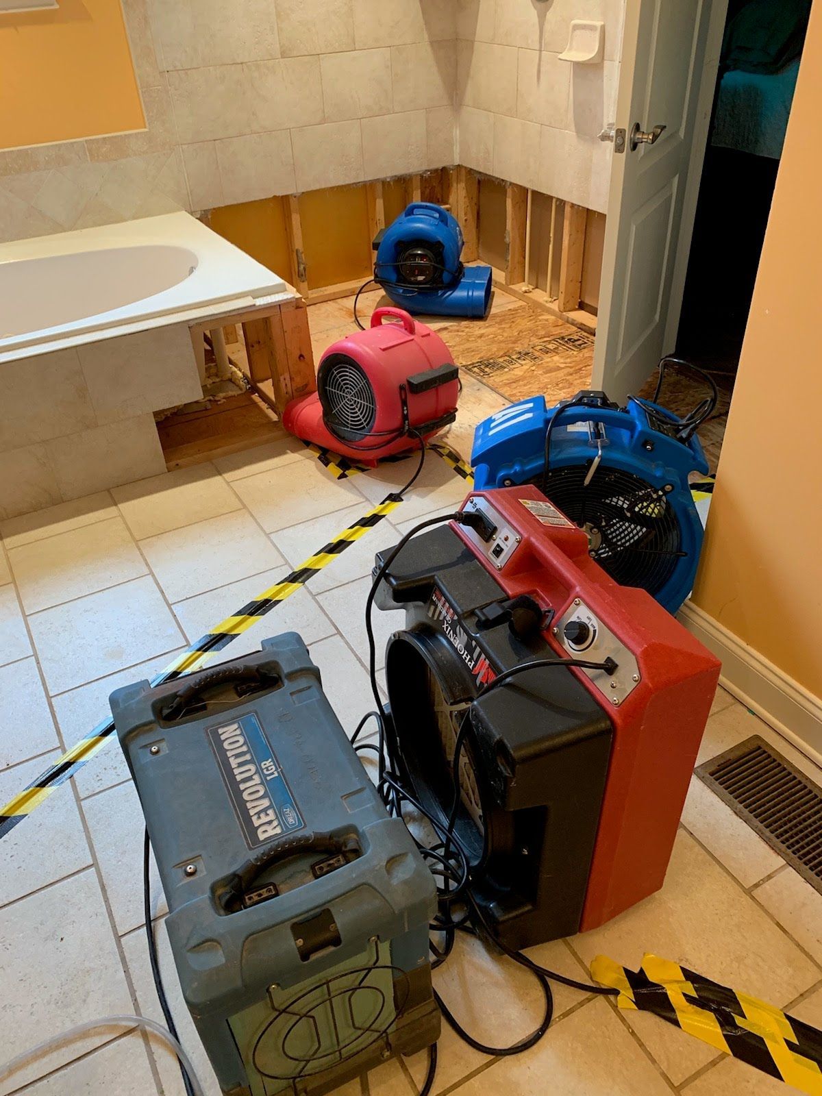 A bathroom with a bathtub and a bunch of appliances on the floor.