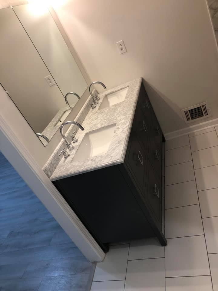 A bathroom with two sinks and a mirror.