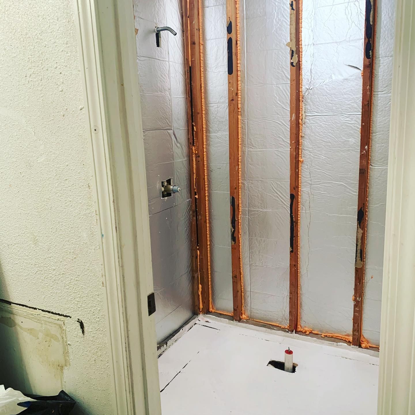 A bathroom with a shower that is being remodeled