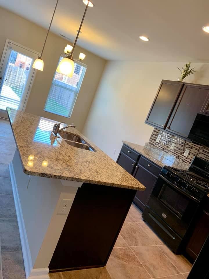 A kitchen with granite counter tops , a stove , and a sink.