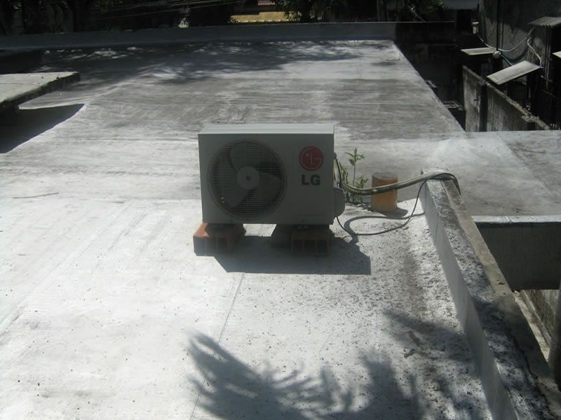 Un acondicionador de aire está en el techo de un edificio.