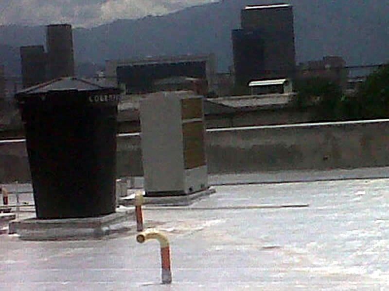 Una azotea con algunos edificios al fondo.