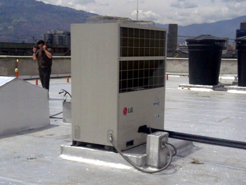 Un acondicionador de aire está en el techo de un edificio.