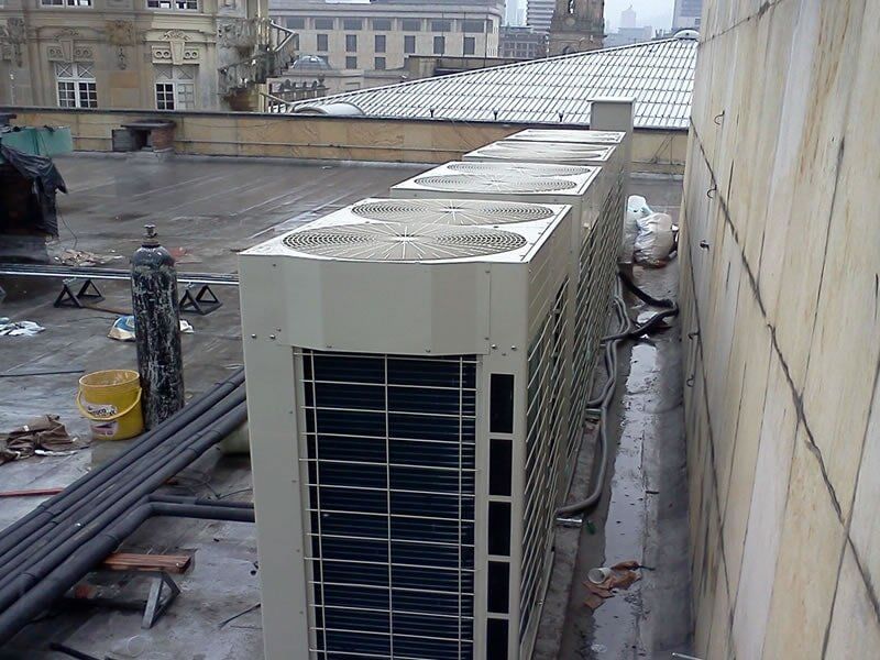 Una fila de aparatos de aire acondicionado en el costado de un edificio.