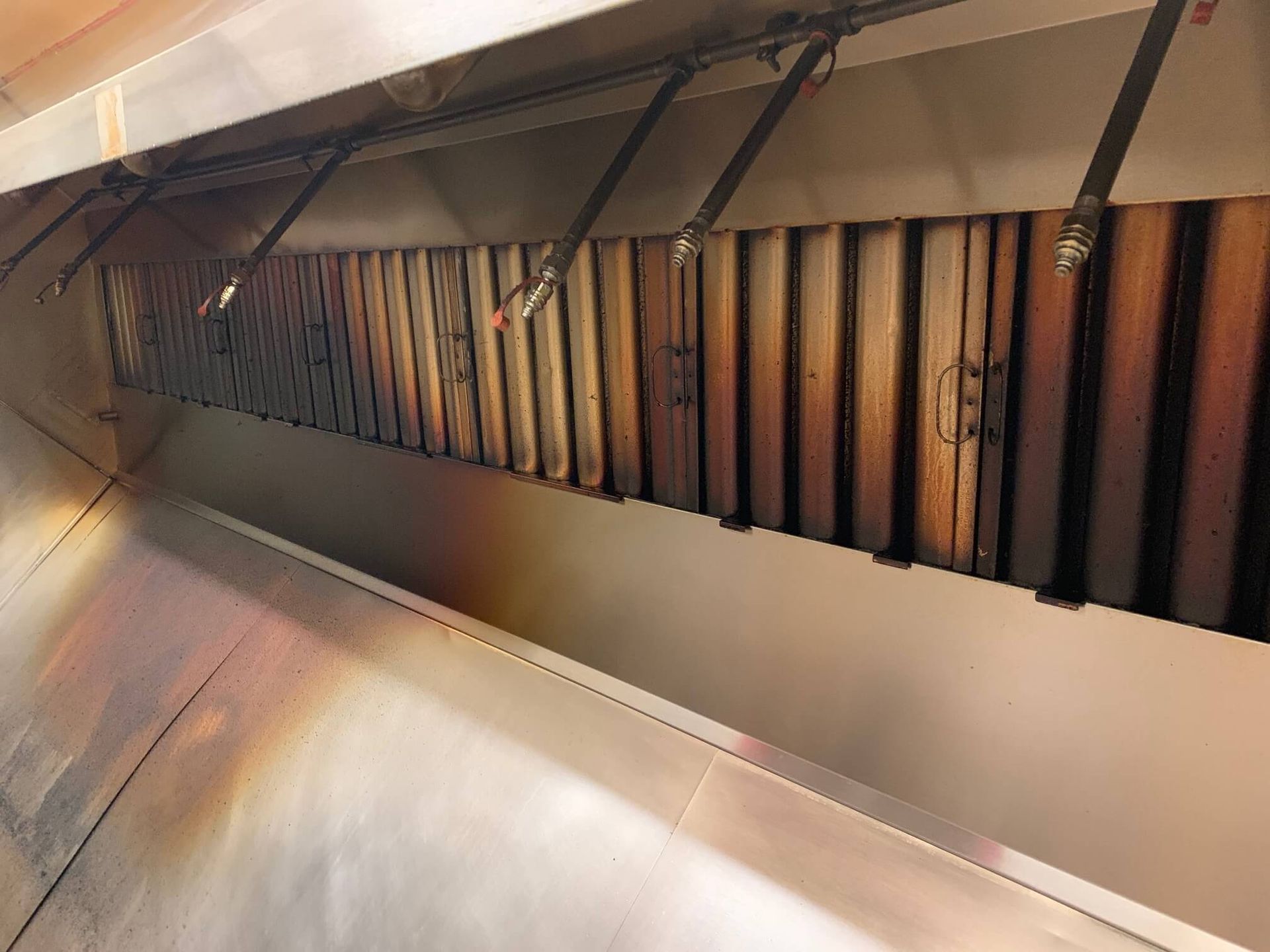 A close up of a stainless steel exhaust hood in a kitchen.