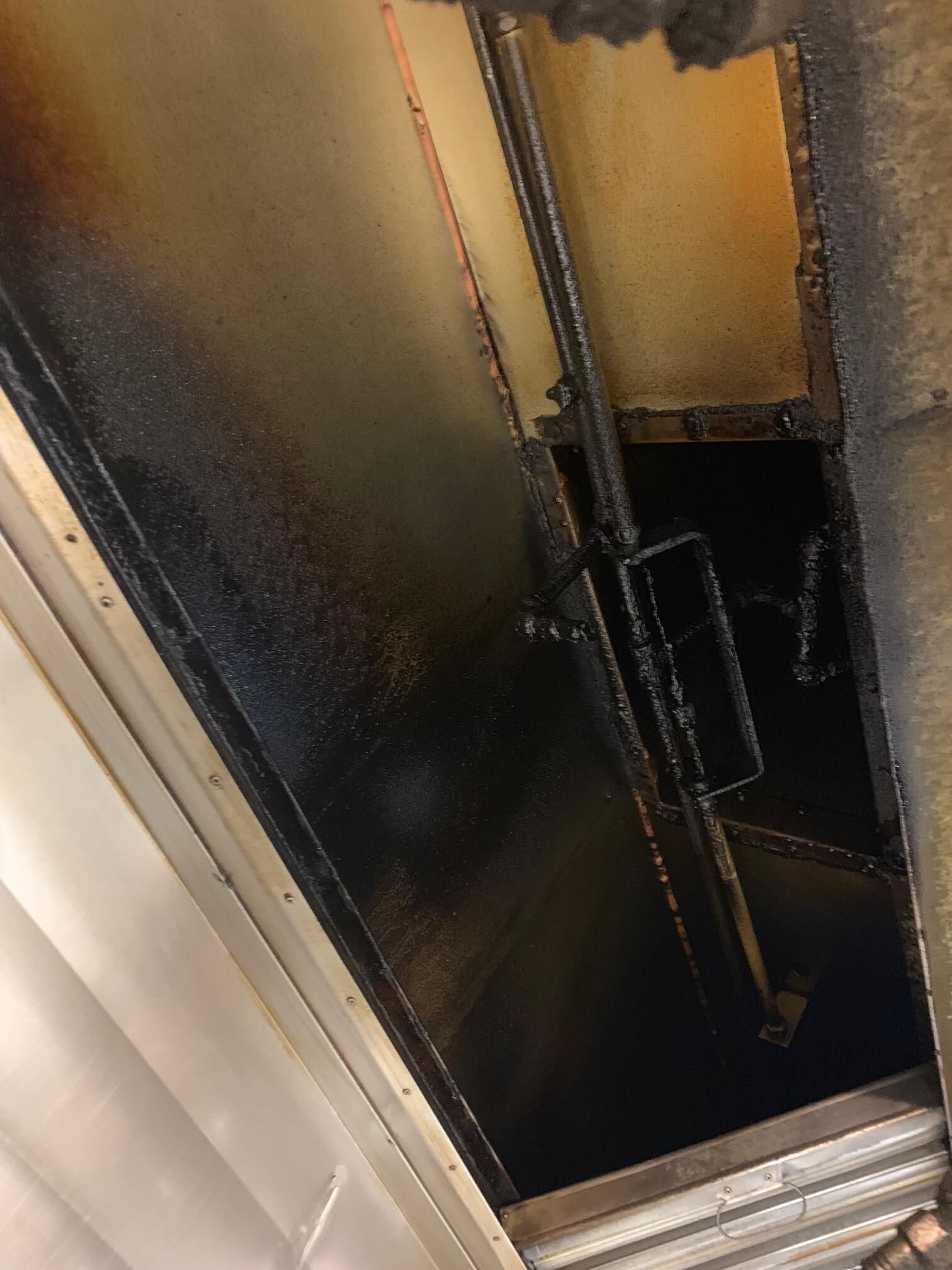 A door with a chain hanging from it is open to a dark room.