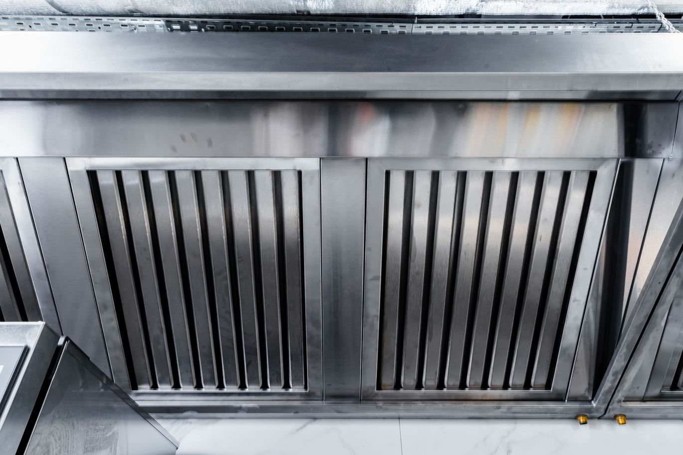 New clean stainless steel hood in professional kitchen.