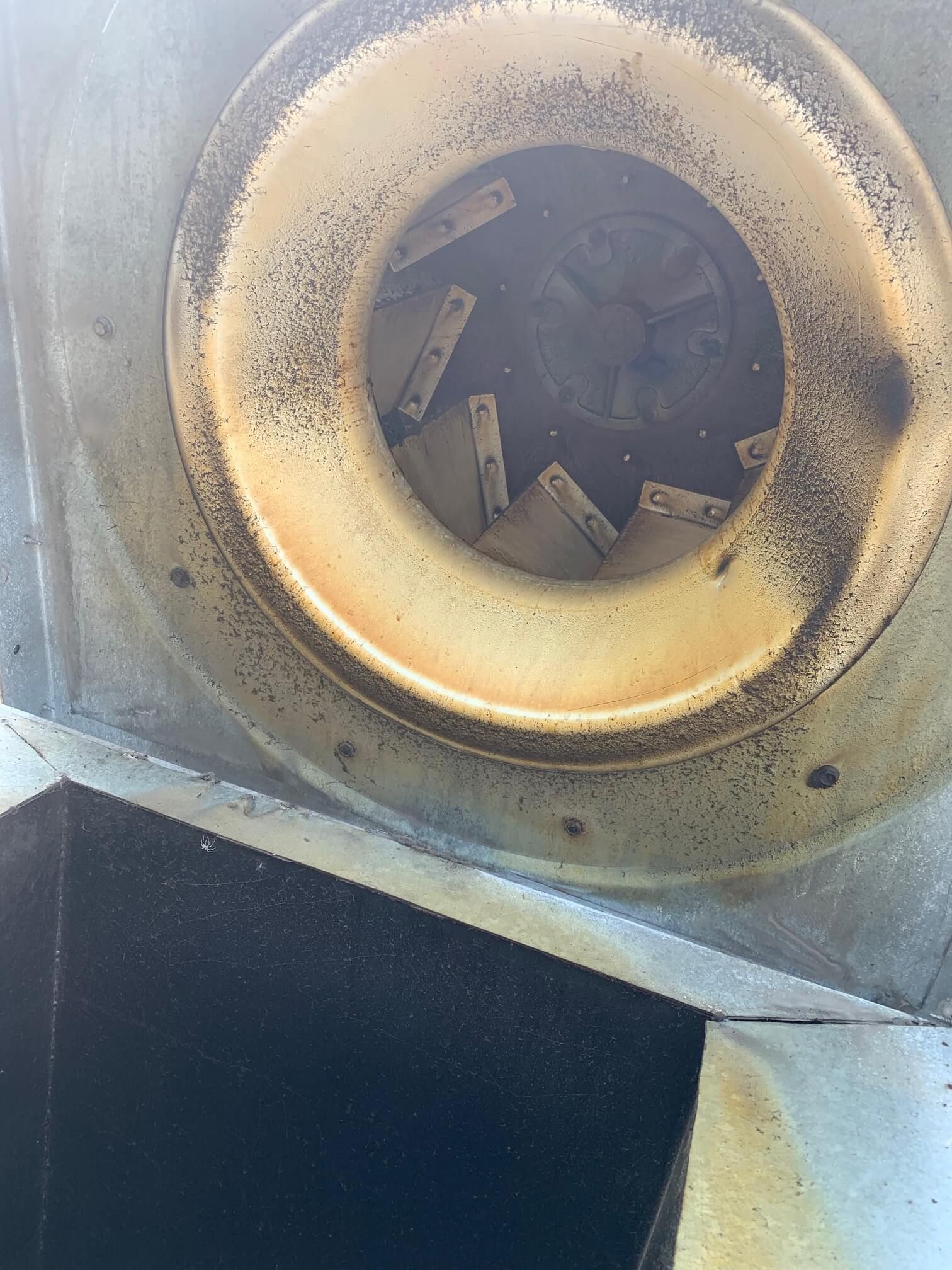 A close up of a dirty fan on a building.