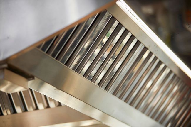 A close up of a stainless steel exhaust hood in a kitchen.