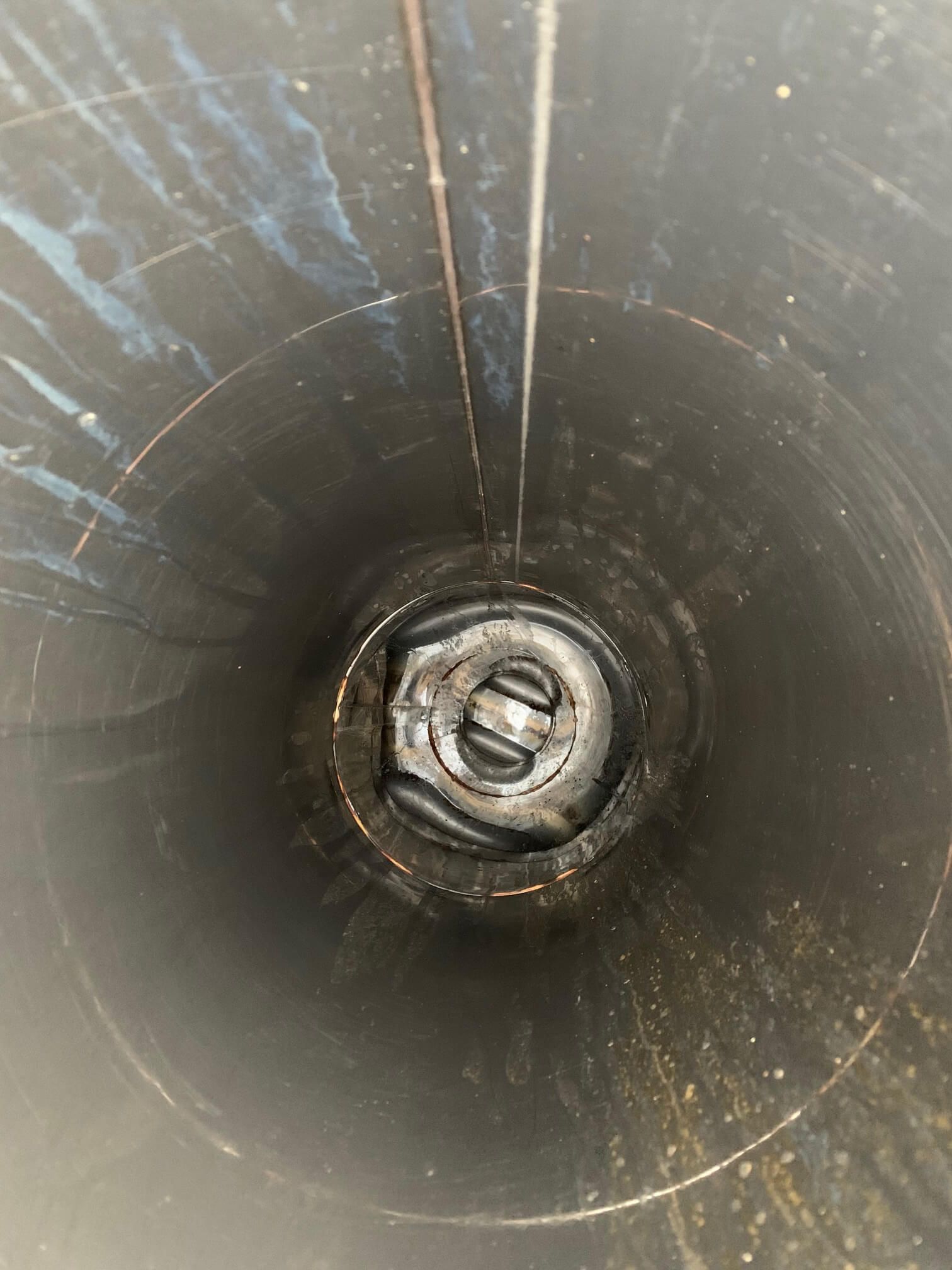 A close up of a metal pipe with a hole in the middle.
