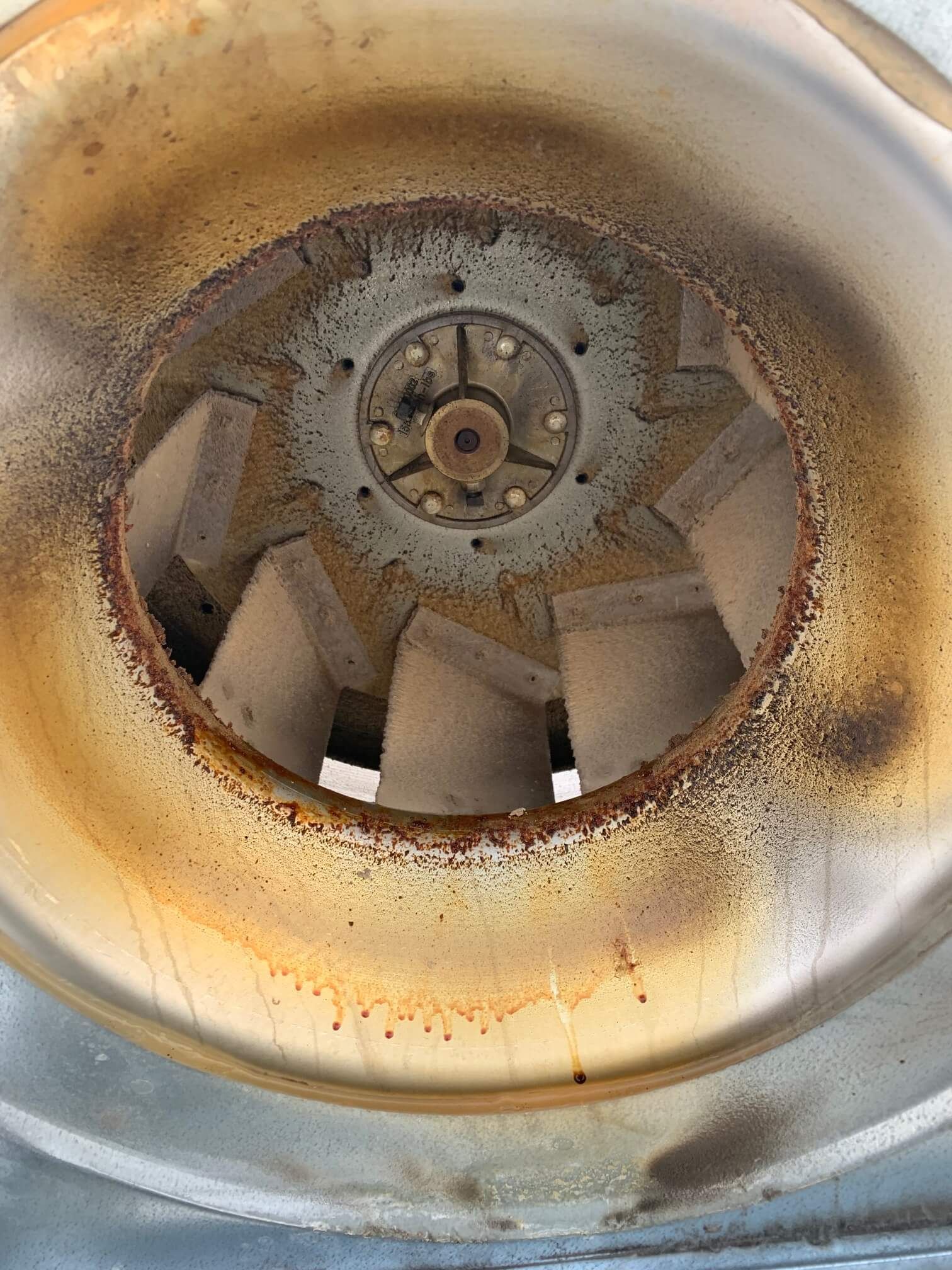 A close up of a rusty fan on a metal surface.