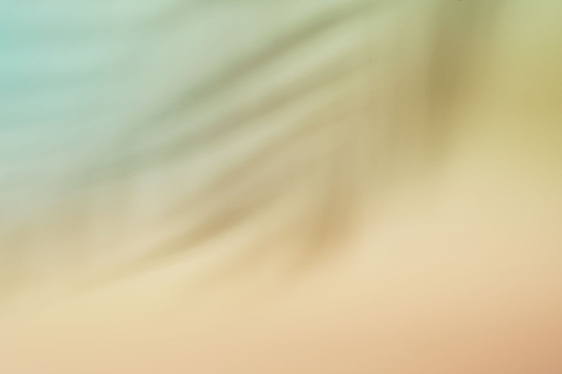 Abstract blurred background with diagonal shadows, featuring soft transitions of teal, yellow, and peach tones.