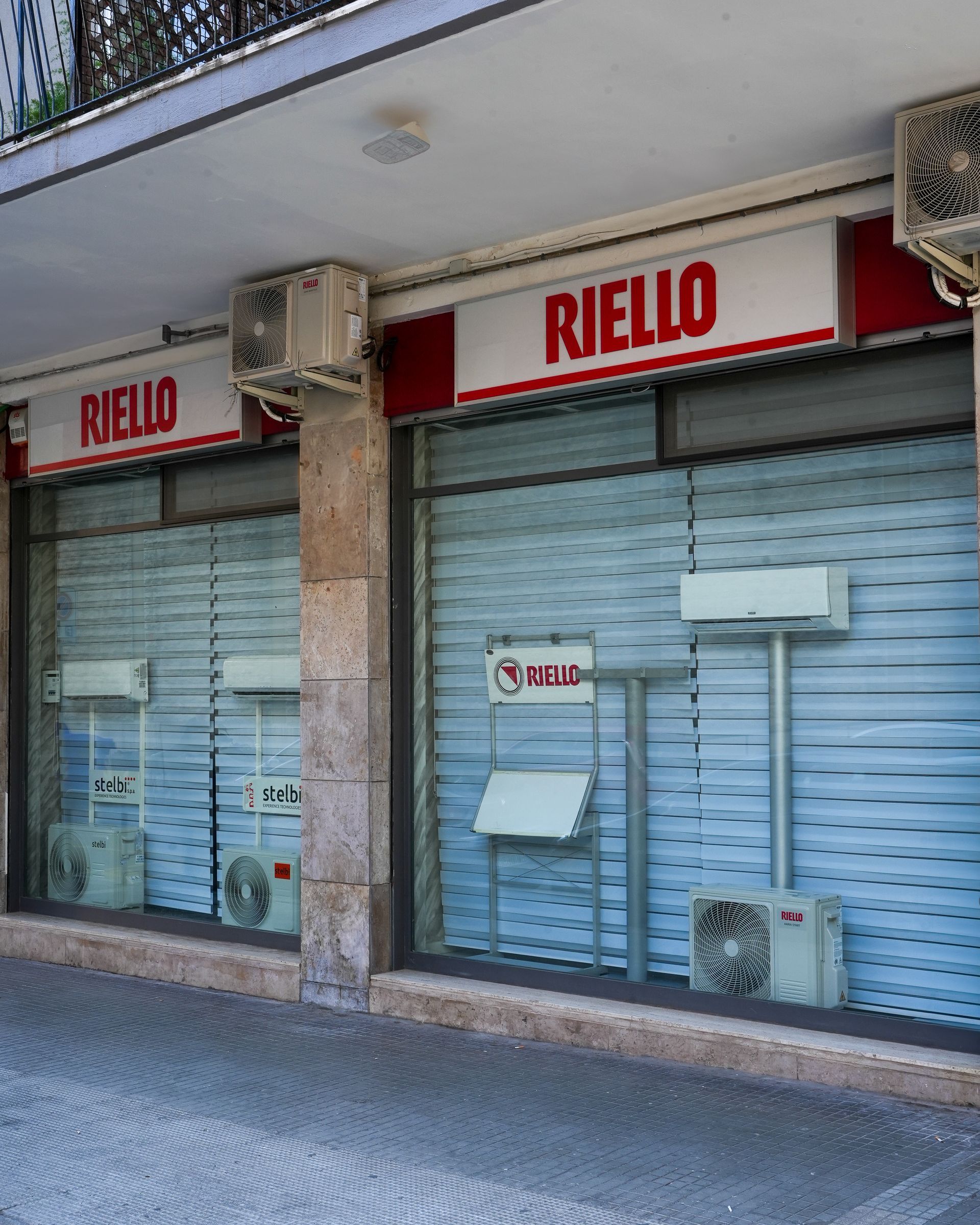 Vetrina del negozio RIELLO con condizionatori esposti. Insegna rossa e bianca sopra.