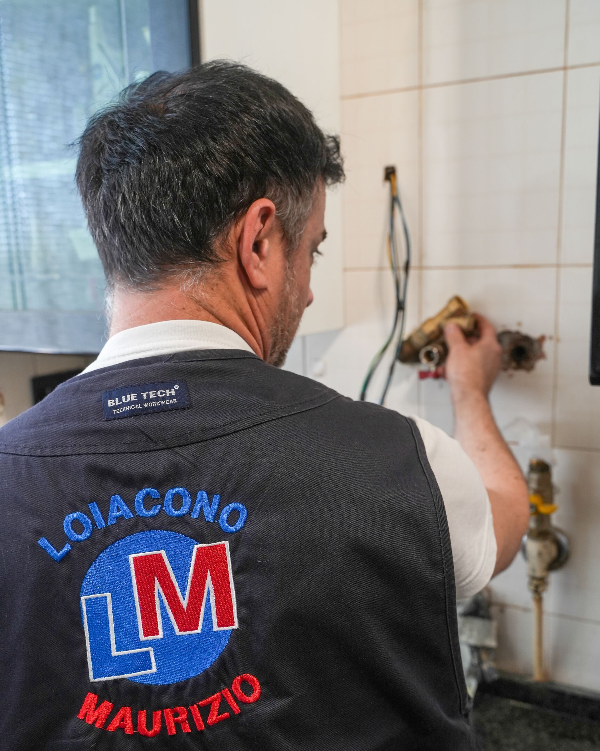 Uomo in uniforme da lavoro, con la scritta