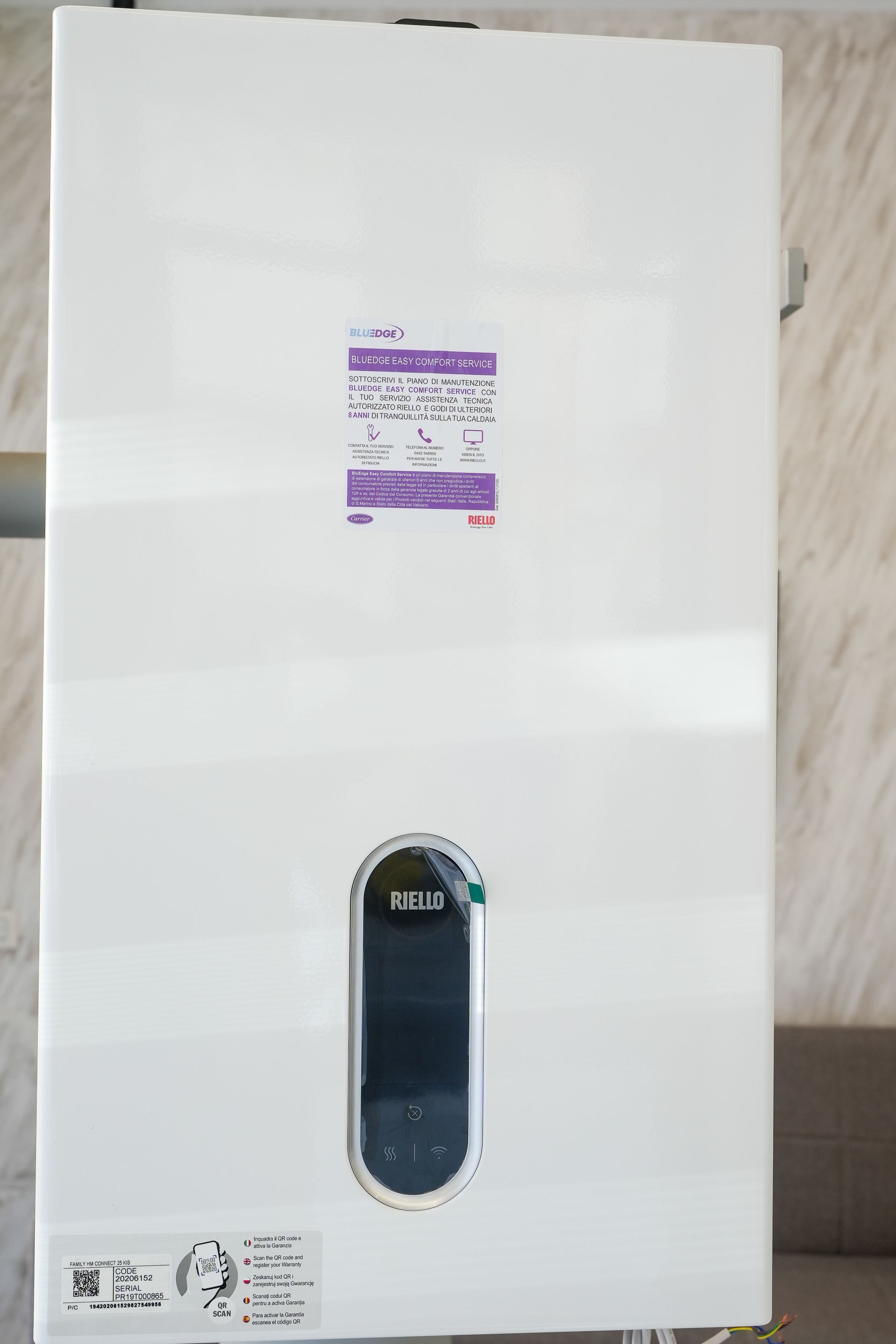 Scaldabagno rettangolare bianco con pannello di controllo ed etichetta sulla parete.