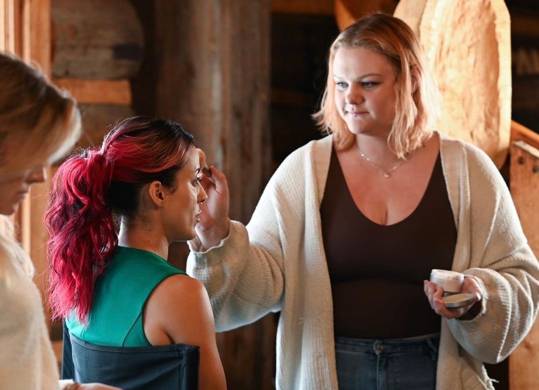A woman is applying makeup to another woman 's face.