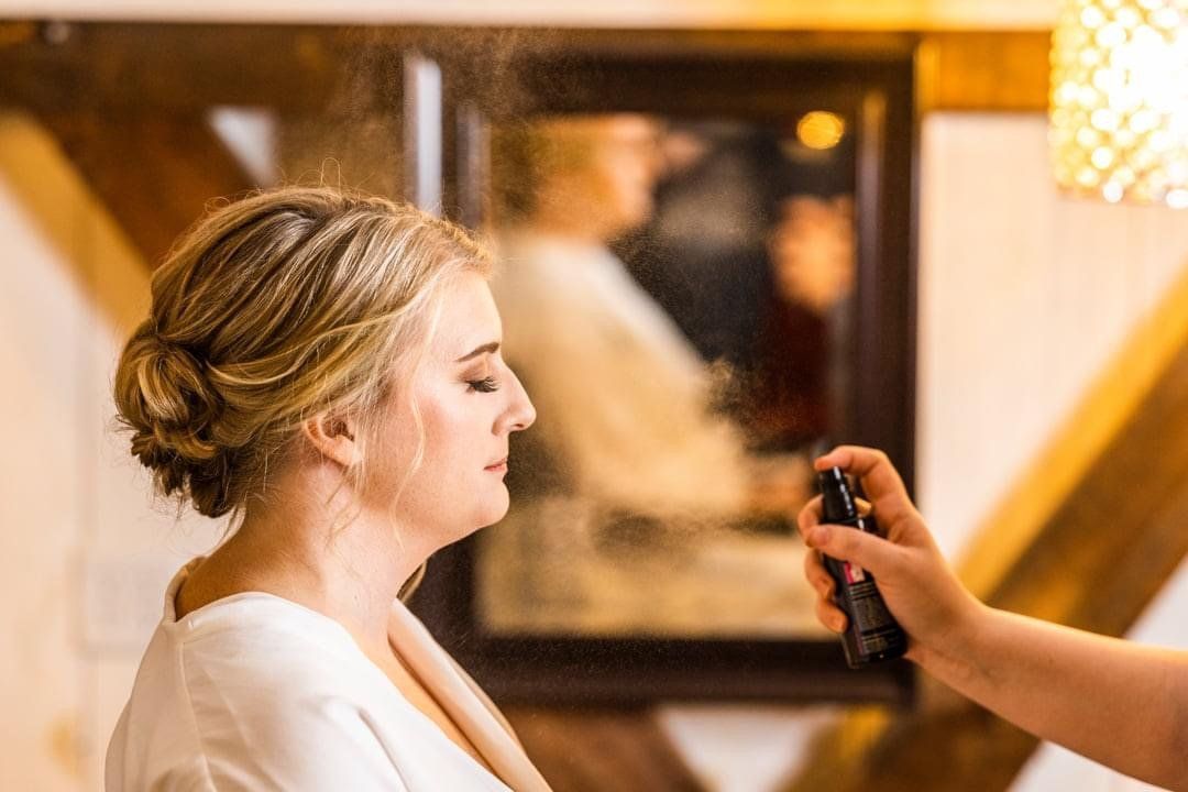 A woman is getting her hair done in front of a mirror.